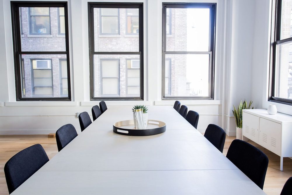 Bright meeting room with linear lighting and timber floor